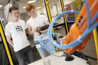 two students using robotic arm